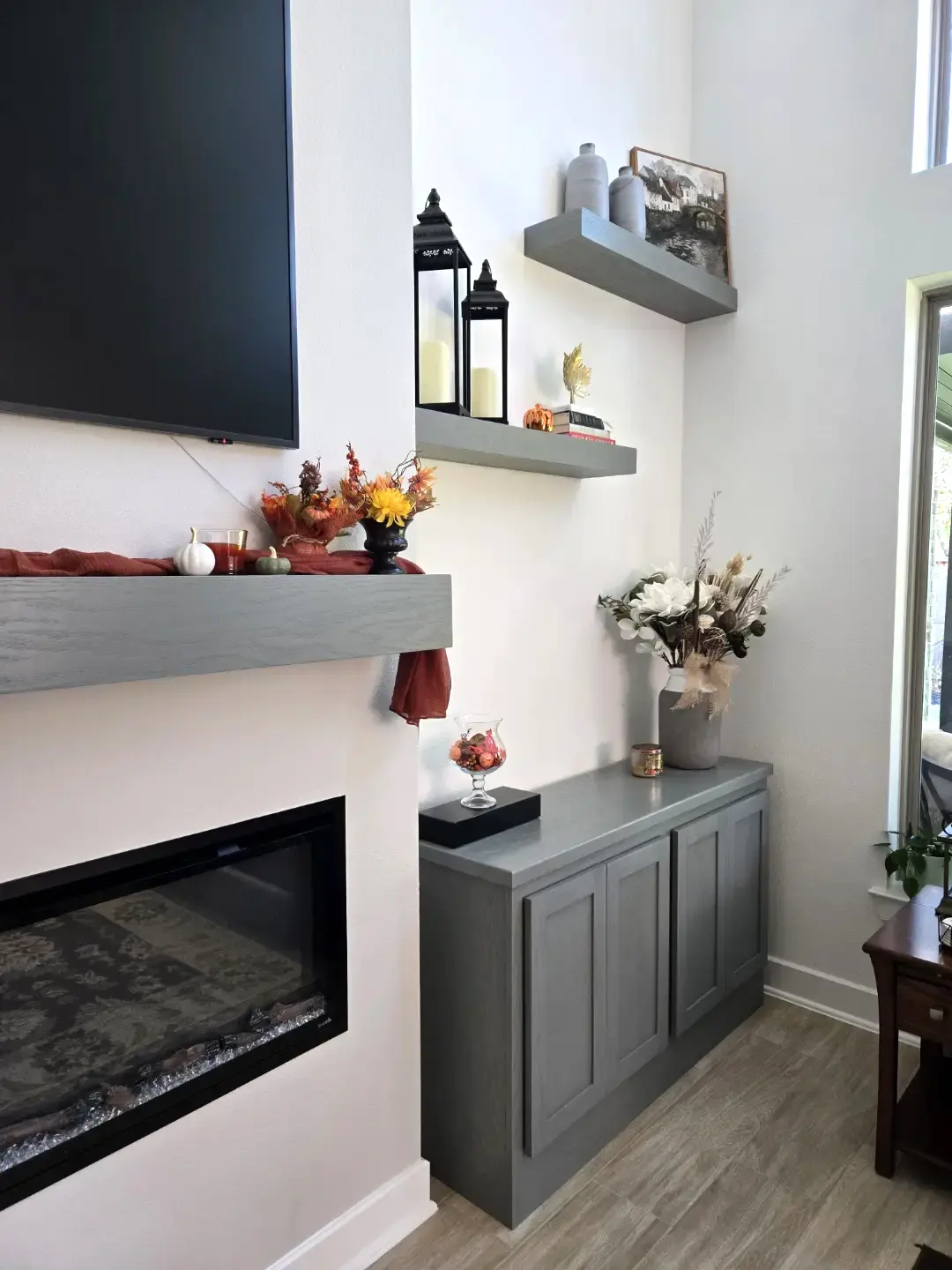 Compact gray cabinetry and shelving beside a fireplace