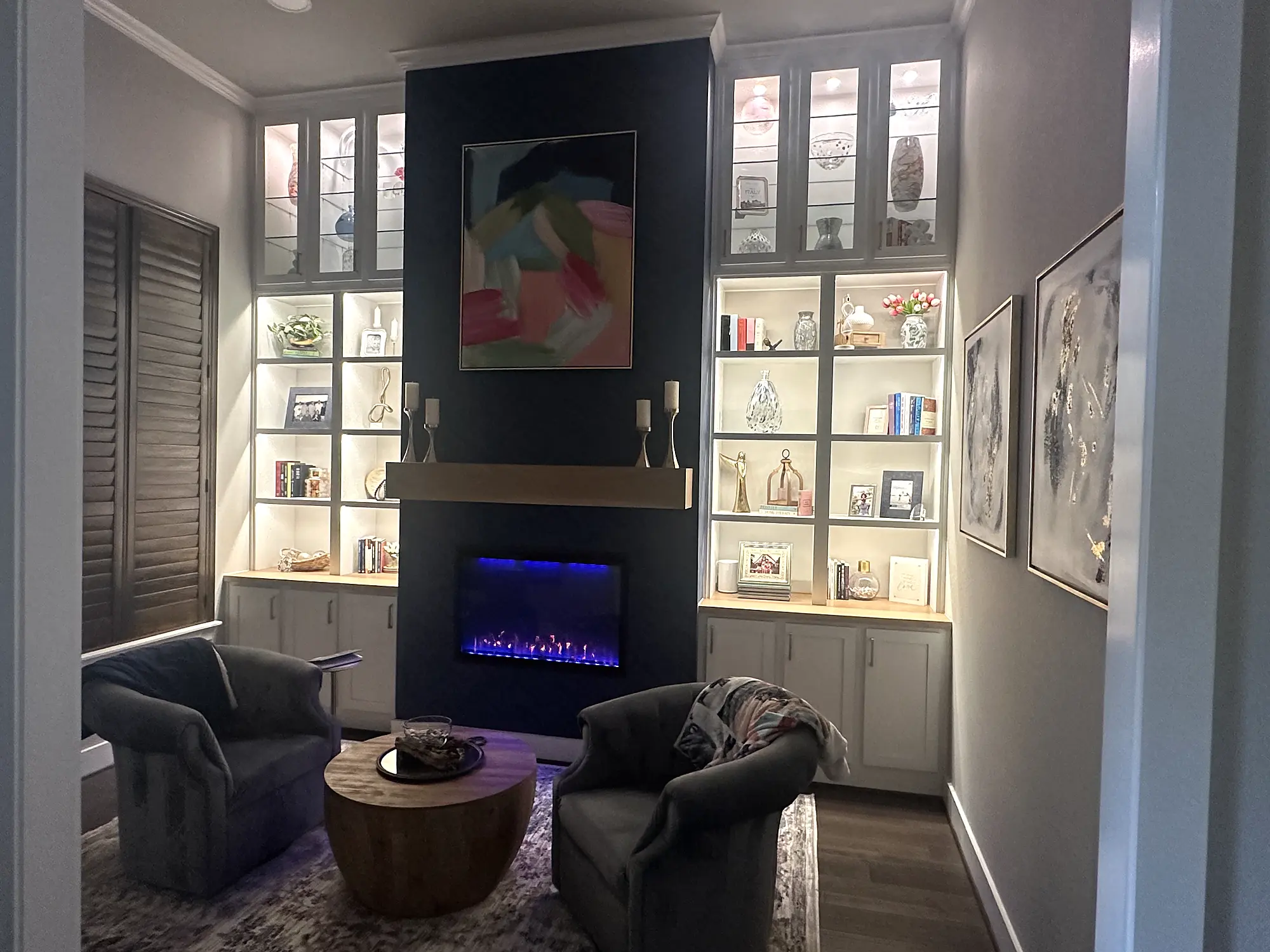 Illuminated fireplace wall with custom cabinetry