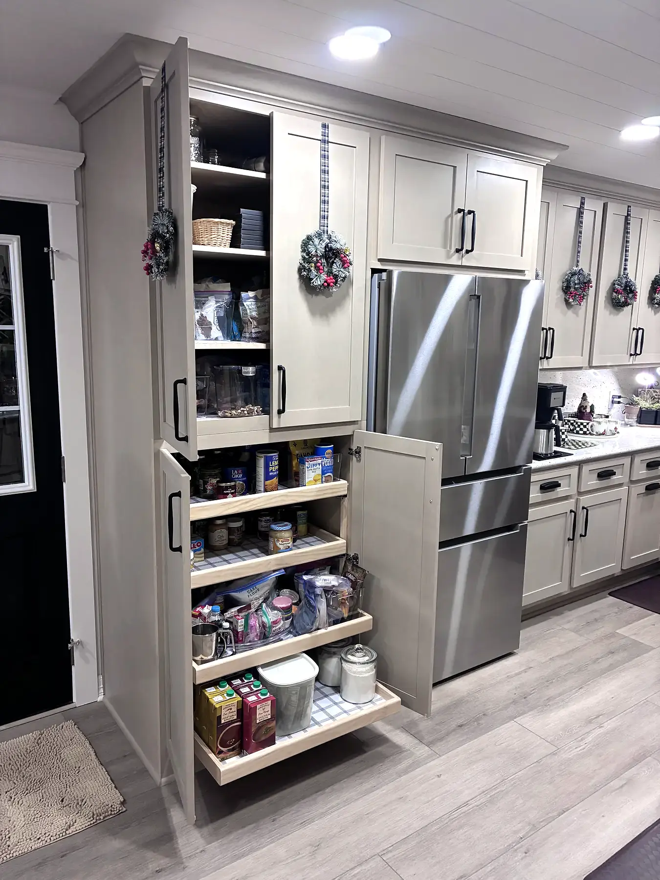 Tall kitchen cabinet opened to reveal a full-height pull-out pantry